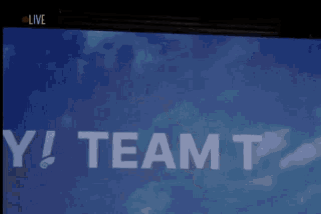 a girl giving a thumbs up in front of a screen that says y! team