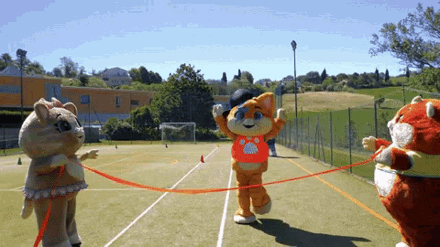 a group of stuffed animals are playing on a court
