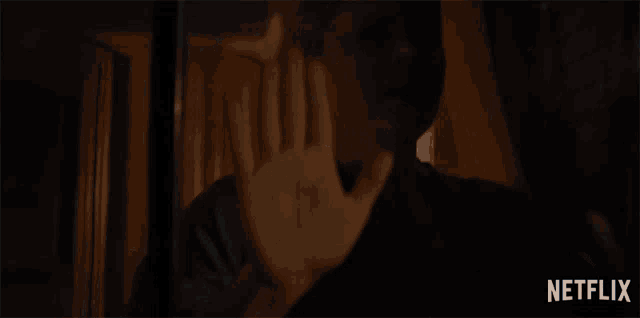 a woman holds her hand up in front of a netflix advertisement