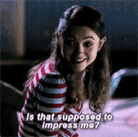 a woman in a striped sweater is smiling and asking is that supposed to impress me ?
