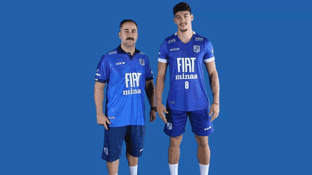 two men wearing blue fiat minas uniforms stand next to each other