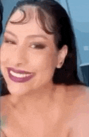 a close up of a woman wearing purple lipstick and smiling .