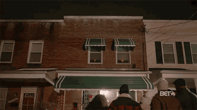 a sign that says merry christmas hangs on a brick building