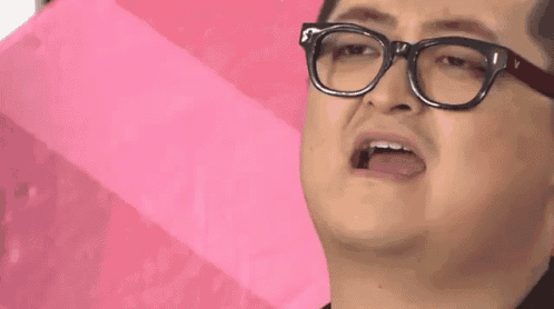 a man wearing glasses is making a funny face .