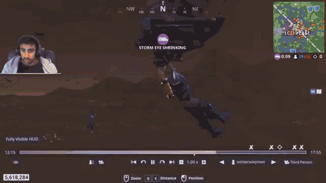 a man playing a video game with a storm eye shrinking flag in the background
