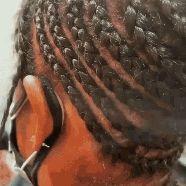 a close up of a person 's braids with a mask on .
