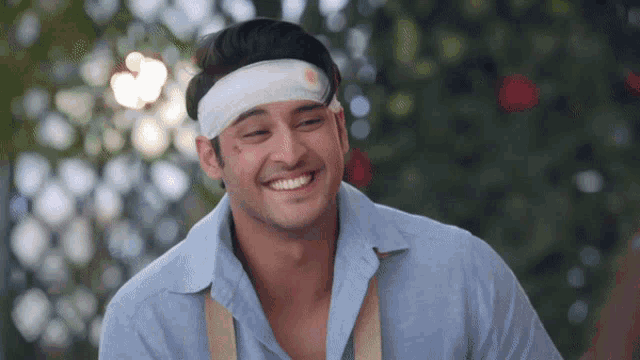 a man with a bandage on his forehead smiles for the camera