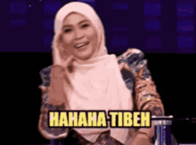 a woman in a hijab is sitting in front of a sign that says '  hahaha tibeh '