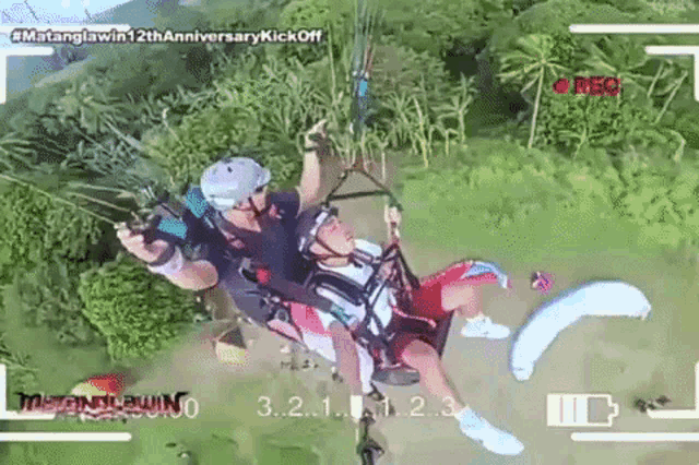an aerial view of a man and a woman parasailing with the words # matanglawin12thanniversary kickoff at the bottom
