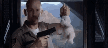 a man is holding a gun and a stuffed rabbit .
