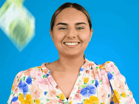 a woman wearing a floral shirt is smiling with a blue background
