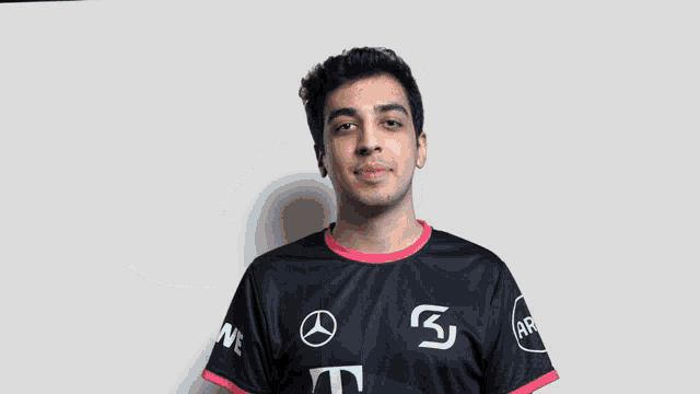 a man wearing a black t-mobile shirt is waving his hand