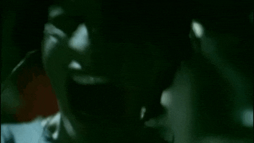 a close up of a person 's face with their mouth open in the dark .