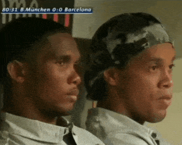 two men are sitting next to each other in front of a screen that says barcelona