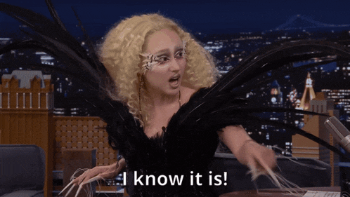 a woman in a black dress with feathers on her wings says i know it is