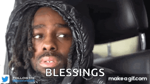 a man with dreadlocks is wearing a black hooded jacket and says blessings