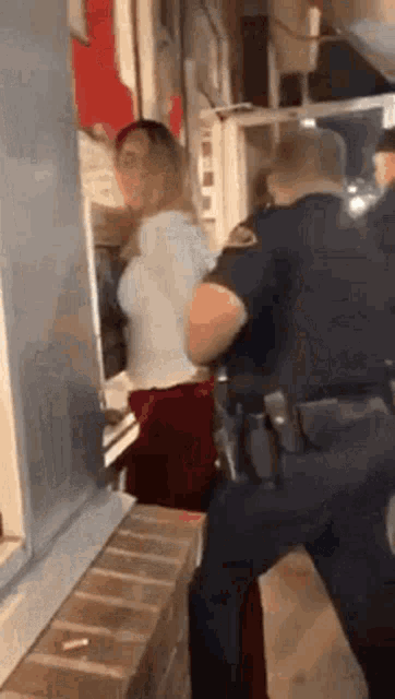 a woman is being held by a police officer in a room .