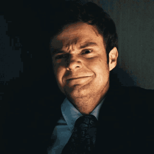 a man in a suit and tie making a face