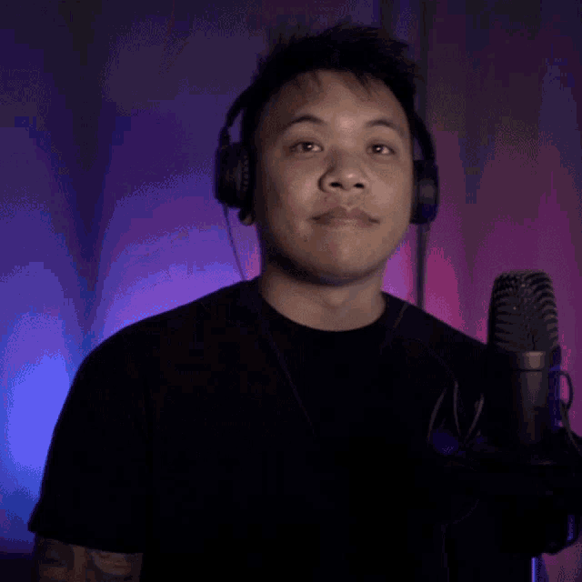 a man wearing headphones is giving a peace sign