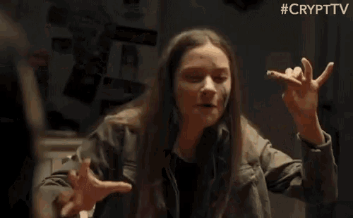 a woman is sitting at a table with her hands outstretched and the words #crypttv behind her