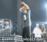 a man is standing in front of a microphone on a stage and says happy butt wiggle day