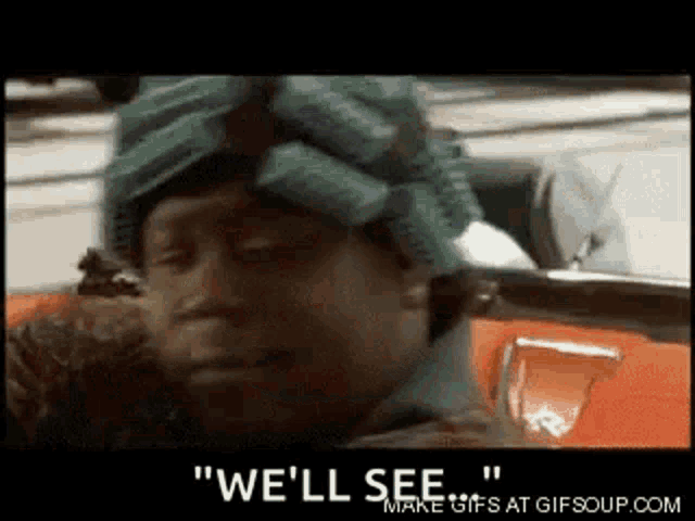 a man wearing curlers on his head is sitting in a car and crying .