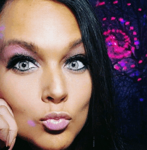 a close up of a woman 's face with her hand on her chin