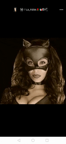 a woman is wearing a cat mask and a cat ears headband .