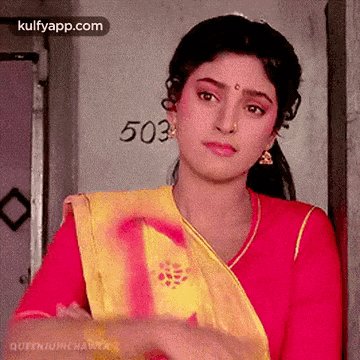 a woman in a red and yellow dress is standing in a doorway .
