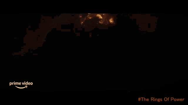 a poster for the rings of power shows a ram surrounded by fire