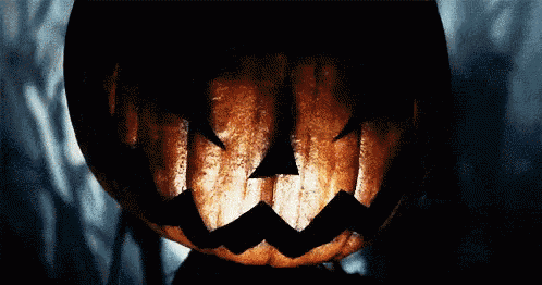 a close up of a pumpkin with a scary face carved into it