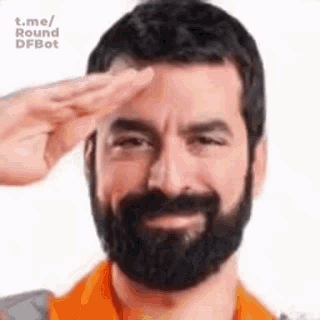 a man with a beard is saluting and smiling .
