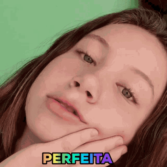 a close up of a girl 's face with the word perfeita written above her