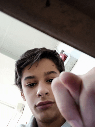 a young boy is taking a picture of himself with his finger