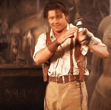 a man in a white shirt and tan pants holds a sword in his right hand