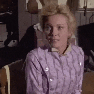 a woman in a purple dress is sitting in a chair in a room .