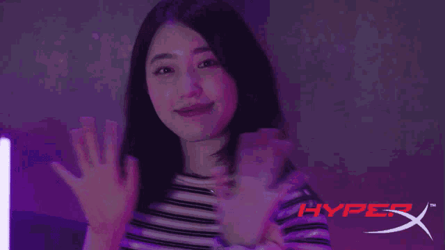 a woman waving her hands in front of a hyper x logo