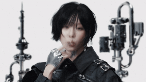 a woman wearing a black jacket and silver gloves is blowing smoke