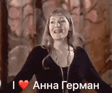 a woman is holding her arms out in front of a sign that says i heart anna german