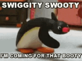 a stuffed penguin with a red nose is standing in a room with a caption that says swiggity swooty