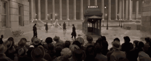 a group of people are gathered outside of a subway station