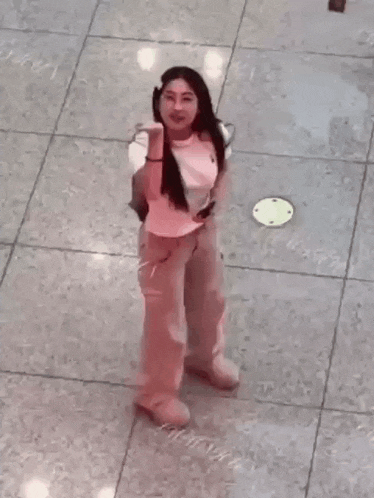 a woman is standing on a tiled floor with her hands in her face .