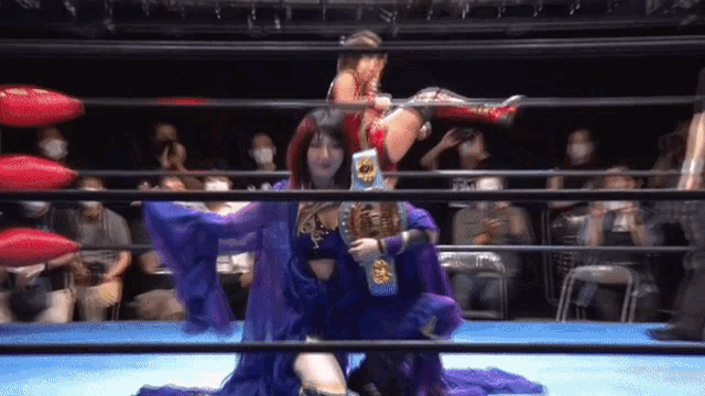 a woman in a purple dress is in a wrestling ring holding a belt that says champion
