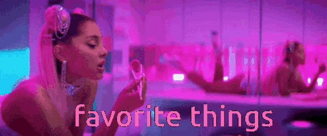 ariana grande is sitting in front of a mirror in a pink room holding a lipstick .