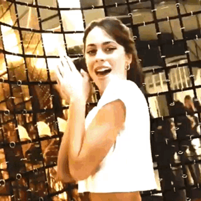 a woman standing in front of a wall with a grid of squares
