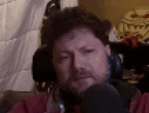a man with a beard is wearing headphones and looking at the camera