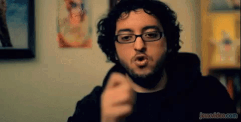 a man with glasses and a beard is making a funny face and the website jeuxvideo.com is visible in the corner