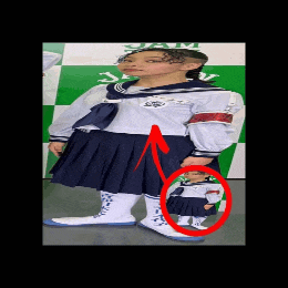 a girl in a school uniform is standing in front of a green and white wall