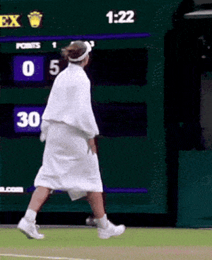 a person walking on a tennis court with a scoreboard behind them that says 30 points