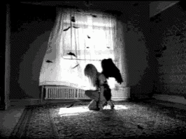 a woman with angel wings is kneeling in front of a window .